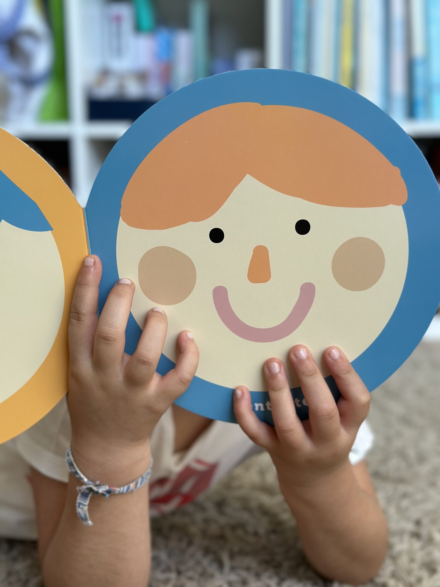 Criança a segurar um cartão com uma cara sorridente