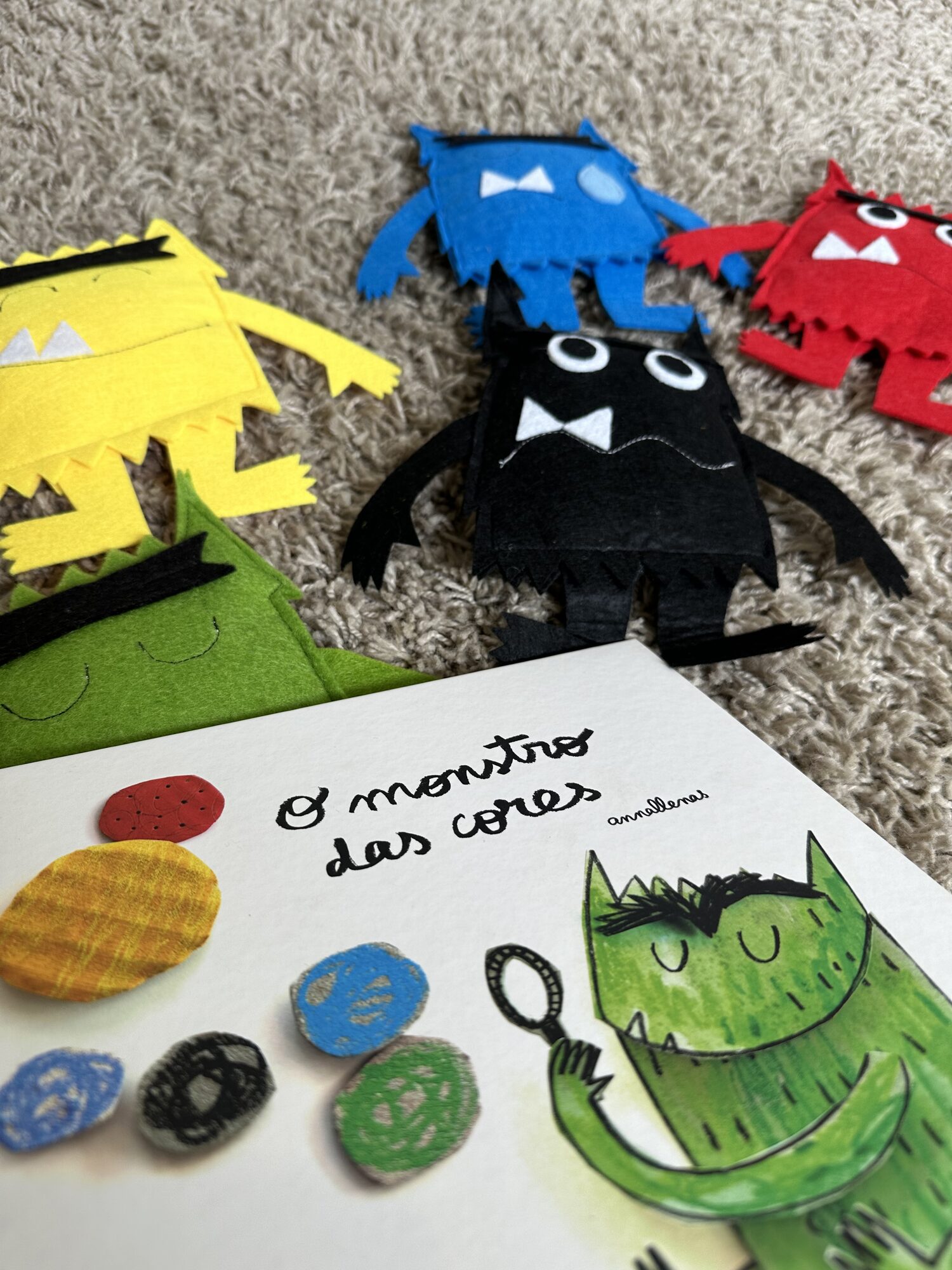 Monstros de feltro ao lado de um livro